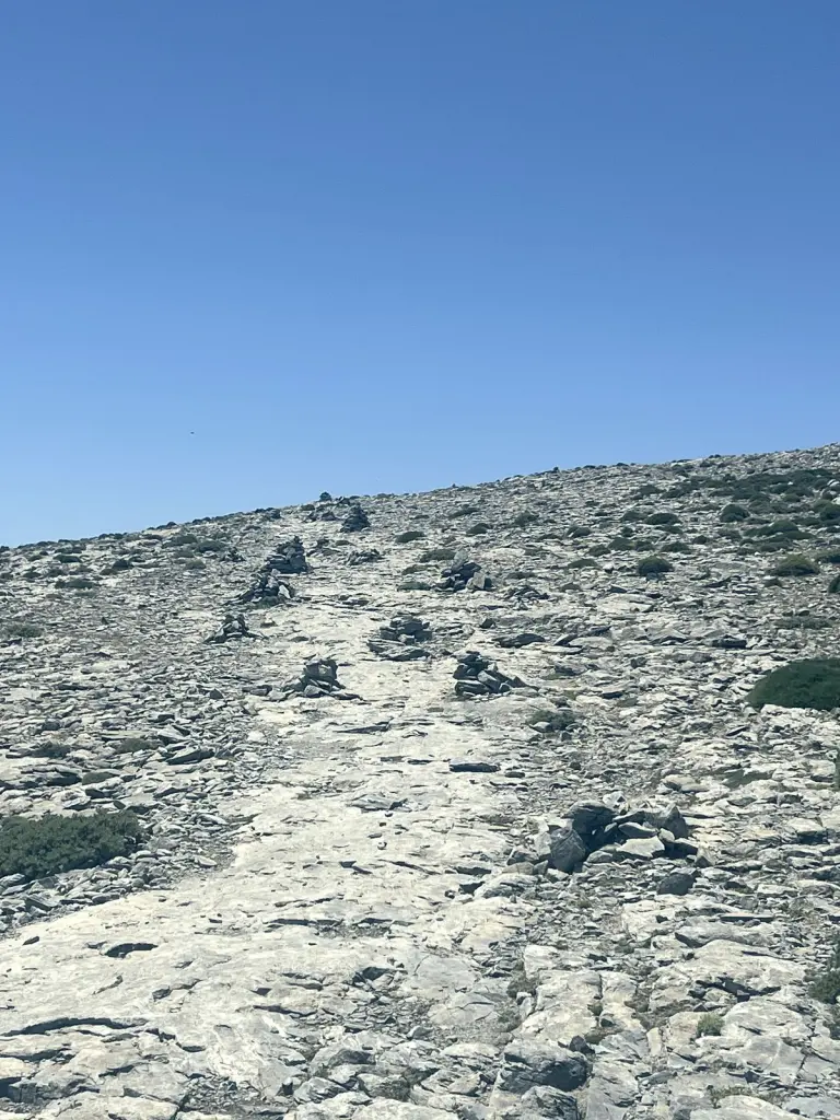 Sendero de piedra caliza con hitos hacia la cumbre