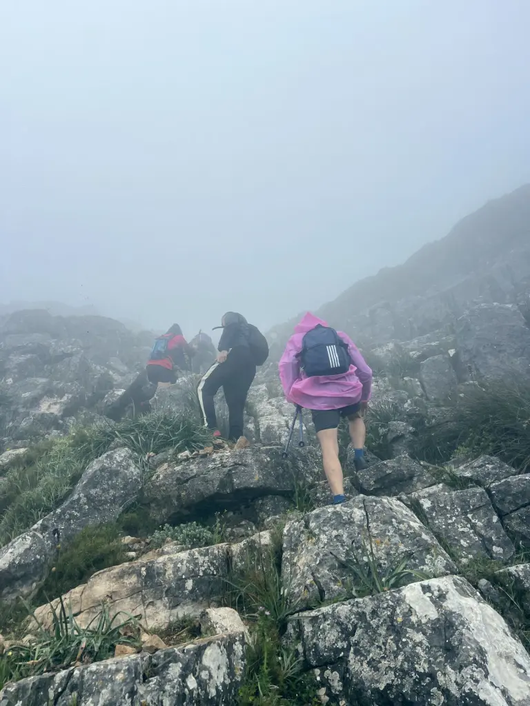 Senderistas subiendo entre rocas en la niebla